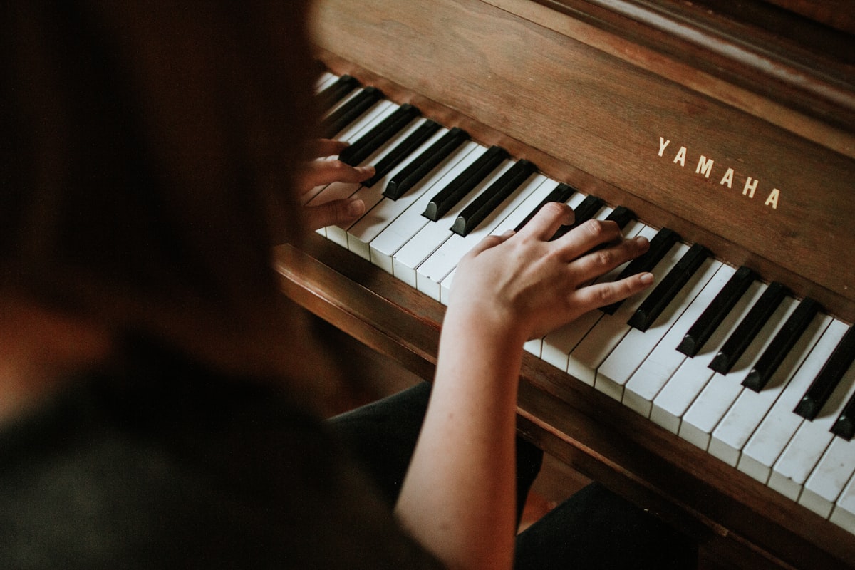 Hands playing piano keys